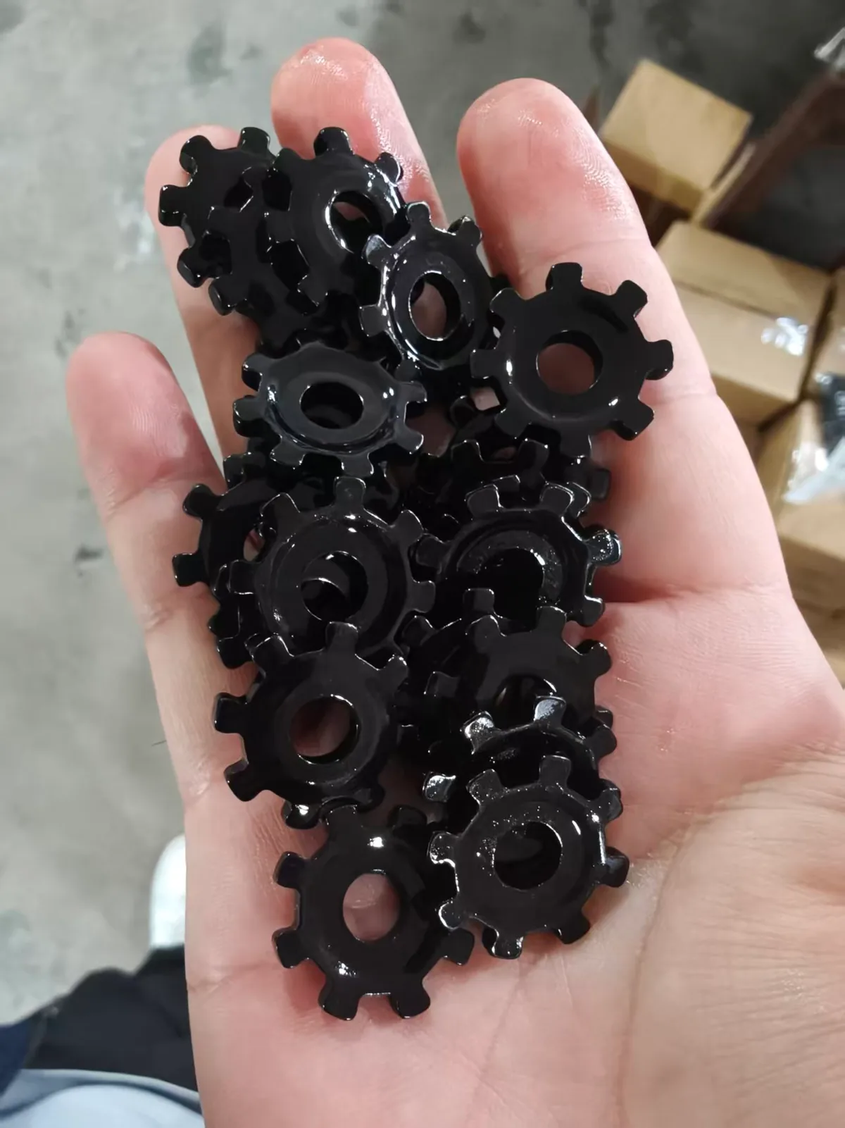 Finished SPCC stamped door lock drive gears sampled at the factory after carbonitriding, blackening and oiling