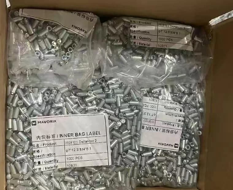 Short steel spacer components grouped in labeled inner bags