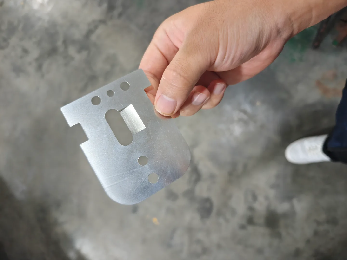 Formed metal component with mounting holes and a slot reviewed during a factory visit