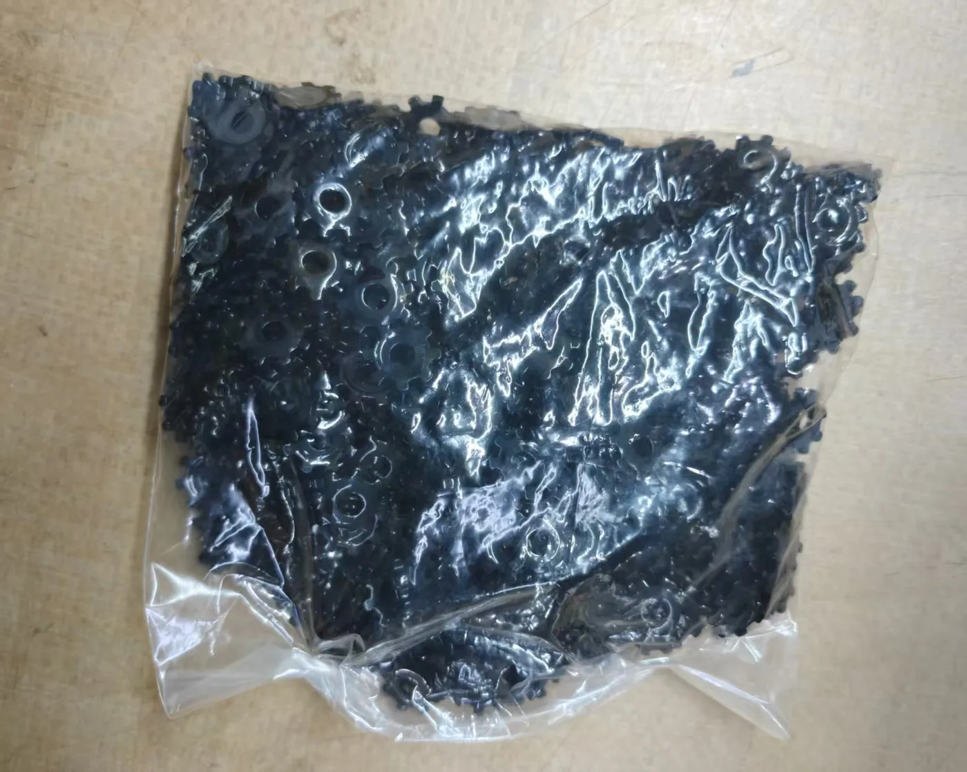 Finished blackened door lock gears with rust-preventive oil grouped in a clear inner bag